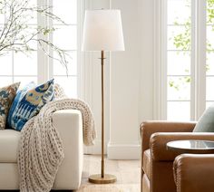 a living room scene with focus on the floor lamp and sofa in the foreground