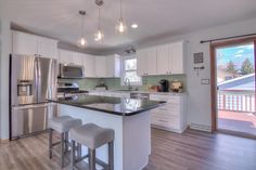 a kitchen with white cabinets and stainless steel appliances