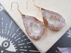 These amazing pieces of stone are matched up in pairs for unique statement earring that will surely get noticed. Each agate slice is hand cut and plated in 14kt gold for when you want to go bold. These are all 100% unique and you will not receive this exact pair. I love the freeform undulations in these stones and the amazing druzy inclusions are to die for. Length: 1.75" Gold fill ear wires Geode Earrings, Crystal Geode, Statement Earring, Agate Geode, In Pairs, Agate Slice, Handmade Jewelry Gift, 14kt Gold, Ear Wires