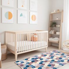 a baby's room with white furniture and pictures on the wall, including a crib