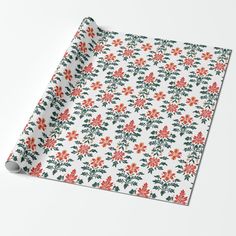 a white wrapping paper with red and green flowers on it, sitting on top of a table