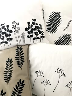 three pillows with black and white designs on them