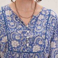 Embrace bohemian charm and effortless style with the Jasmine Blue Bohemian Tunic. Crafted from 100% viscose, this tunic offers both comfort and breathability, perfect for all-day wear. The vibrant blue pattern adds a lively touch to your look, making it a standout piece in your wardrobe. The 3/4 sleeves provide a relaxed yet polished look, while the inner lace detail on the placket adds a touch of femininity and elegance. Featuring a half placket adorned with shell buttons, this tunic exudes und Blue Relaxed Fit V-neck Tunic, Flowy Bohemian Boho Dress In Viscose, Bohemian V-neck Rayon Peasant Top, Flowy Bohemian Viscose Boho Dress, Flowy Bohemian Viscose Dress, Bohemian V-neck Tunic With Floral Print, Blue Casual Tunic With Relaxed Fit, Bohemian Patterned Rayon Blouse, Blue Relaxed Fit Tunic Blouse