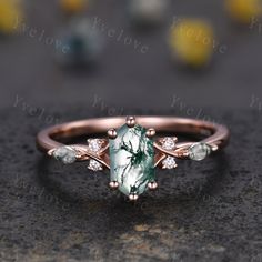 this is an image of a ring with green and white stones on the side,