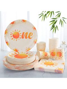 an assortment of plates and cups with the word one painted on them, sitting on a table