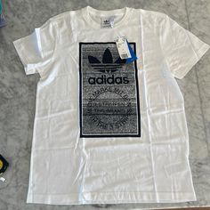 White Never Worn Adidas Logo Tee. “Traction Tongue” Size Large. Crisp! Casual Adidas Shirt With Logo Print, Casual White Adidas Shirt, Adidas Casual Shirt With Logo Print, White Casual Adidas Shirt, Adidas Crew Neck Shirt With Graphic Print, White Cotton Tops With Graphic Design, White Cotton Top With Graphic Design, Adidas Crew Neck Shirt With Letter Print, Adidas Letter Print Top For Streetwear