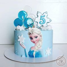 a frozen princess birthday cake with blue frosting and decorations on the top is shown