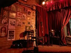 a room with red curtains and pictures on the wall