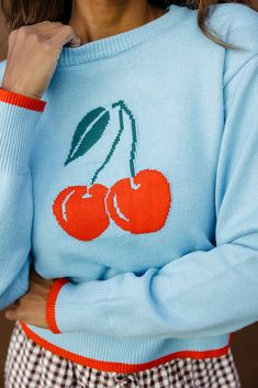 The Cherry Sweater brings a fun pop to any outfit! It features a vibrant cherry graphic on a light blue background, adding a touch of sweetness to your wardrobe. The red trim on the sleeves and hem complements the cherry design perfectly. Its soft, cozy material and relaxed fit make it ideal for cool weather, while the bold graphic keeps it cute and stylish. soft + stretchy slightly cropped // paired with the central park gingham pants in saddlebrown Athleisure Mom, Cherry Graphic, Platform Slip Ons, Cherry Sweater, Chic Fall Fashion, Clogs Heels, Cherry Design, Play Shoes, Mom Accessories