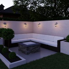 an outdoor seating area is lit up at night with lights on the wall and trees