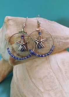 Ocean Tides and Waves Sapphire Blue Beaded Starfish Earrings. Blue glass seed beads strung on a silver colored hood. Starfish charm position in the center of hoop. These are a must for beach trip or any summer vacation event. Makes a great gift. Starfish-shaped Beaded Beach Jewelry, Blue Star Shaped Jewelry For Vacation, Blue Star Jewelry For Vacation, Blue Hoop Jewelry For The Beach, Blue Starfish Charm Jewelry For The Beach, Starfish-shaped Beaded Jewelry For The Beach, Blue Starfish Charm Jewelry For Summer, Summer Beaded Starfish Jewelry, Blue Summer Jewelry With Starfish Charm