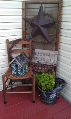 a wooden chair sitting on top of a porch next to a potted plant and star