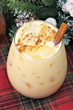 a close up of a drink in a glass with a cinnamon stick sticking out of it