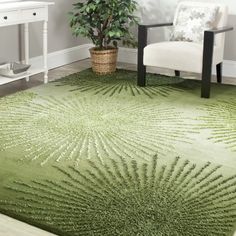 a living room with a green rug on the floor and a white chair in front of it