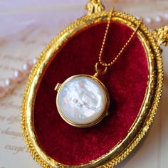 Introducing our unique round locket pendant that combines classic and modern design elements! One side features a beautiful piece of natural mother of pearl while the other side showcases delicate hollow patterns in gold vermeil. This locket opens up to reveal a small space where you can keep a special photo, message, or perfumed ball close to your heart. The natural patterns and elegant glow of each piece of mother of pearl are one-of-a-kind, making this pendant truly unique. The necklace is ad Elegant Silver-colored Gold-plated Locket Necklace, Elegant Silver Gold-plated Locket Necklace, Elegant Silver Color Gold Plated Locket Necklace, Elegant Gold-plated Medallion Locket Necklace, Elegant Gold Plated Silver Locket Necklace, Elegant Gold Locket Necklace With Round Pendant, Elegant Gold Plated Medallion Locket Necklace, Elegant Medallion Locket Necklace In Gold Plated, Elegant Round Pendant Locket Necklace As Gift For Her