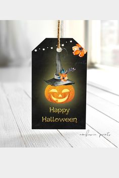 a halloween treat bag with a pumpkin on it and a witch's hat hanging from the top