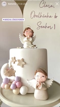 a white cake with angel figurines on top