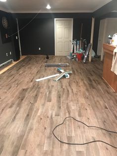 a room with hard wood flooring and tools on the ground in front of it