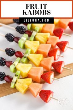 fruit kabobs are arranged on skewers with berries and pineapples