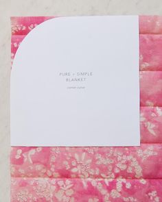 a piece of paper on top of pink and white fabric with the words pure simple blanket