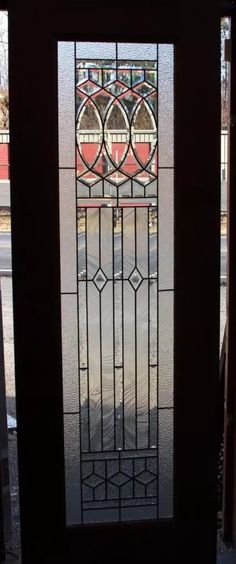 a stained glass door in front of a window with an iron design on the side