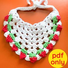 a crocheted bib is hanging on an orange wall