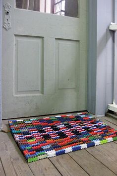 a multicolored rug on the floor in front of a door