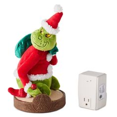 an elf stuffed animal sitting on top of a wooden base next to a power outlet