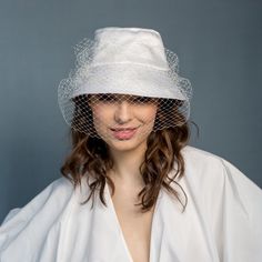 Our ultra-femme bucket hat is made of ivory satin (100% cotton). It is decoratet with french veiling. It is very elegant, a little bit crazy and fashionable. It has also small round pedant with logo boZka. Size 55-58cm RETURNS AND EXCHANGE DETAIL Returns must be made within 14 days (date on the post mark is important). RETURNS FROM OUTSIDE EUROPEN UNION - we accept but they are not fully refounded. Please note that shipping fees are not refundable. We also LEAVE APPROXIMATELY 25-30% FEE - it is White Brimmed Cloche Hat For Wedding, White Short Brim Cloche Hat For Weddings, White Cloche Hat With Short Brim For Wedding, Summer Wedding Bucket Hat, Tulle Hat For Weddings And Kentucky Derby, White Summer Wedding Veil, Elegant White Bucket Hat, White Cloche Hat With Curved Brim For Wedding, Chic Brimmed Cloche Hat For Wedding