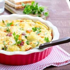 a casserole dish with vegetables and bread on the side, ready to be eaten