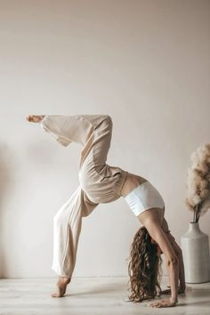 a woman is doing a handstand on the floor