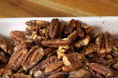 a white bowl filled with nuts on top of a wooden table