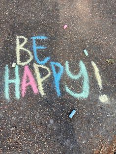 the words be happy written in chalk on asphalt