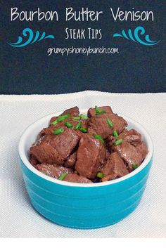 a blue bowl filled with beef sitting on top of a white table cloth next to a sign