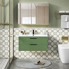 a bathroom with green and white tiles on the walls