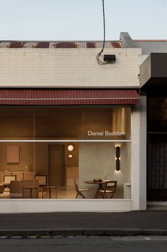 an empty storefront with chairs and tables in the window