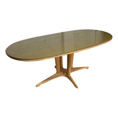 an oval wooden table with two leaves on the top and one leaf at the base