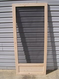 a wooden frame sitting on the side of a building next to a door and window