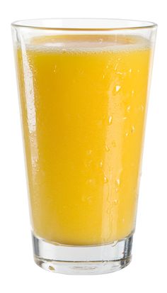 a glass filled with orange juice on top of a white table