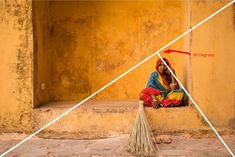 a woman sitting on the ground next to a broom