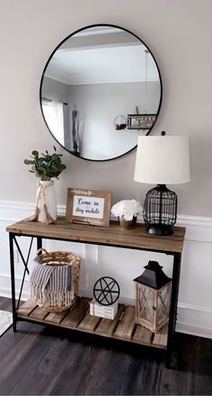 a wooden table topped with a mirror next to a lamp