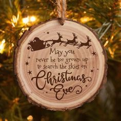 a wooden ornament hanging from a christmas tree with the words, may you never be too grown up to search the skies on christmas eve