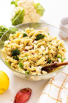 a bowl filled with pasta and broccoli on top of a table