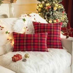 a couch with christmas decorations on it next to a christmas tree and other holiday items