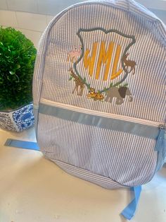 Send your student off to school in style! This seersucker backpack is going to look darling hanging in the classroom! It is the perfect way to display your little one's initials or favorite theme in the classroom. Make your backpack extra special by adding a motif or frame. If there is a design you do not see, please ask me to create it for you, as I can embroider pretty much any design you want! If your little guy loves construction vehicles, alligators, firetrucks or dinosaurs, or your daughter prefers ballet, flowers, rainbows, or flamingo, we can design it! Regular Size (15x13x5) Toddler Size (12x9x4) Preppy White School Backpack, White Preppy Backpack For Students, White Preppy School Backpack, Preppy White Rectangular Backpack, Preppy White Standard Backpack, White Preppy Backpack, Preppy Backpack For School Events, Preppy School Event Bag For Back To School, Embroidered Backpack For Students