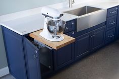 a kitchen sink with a mixer on top of it in front of a countertop