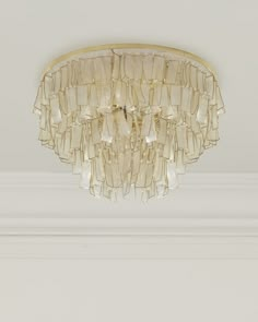 a chandelier hanging from the ceiling in a room with white walls and trimmings