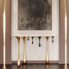 three gold drips hang from the wall in front of a black and white painting