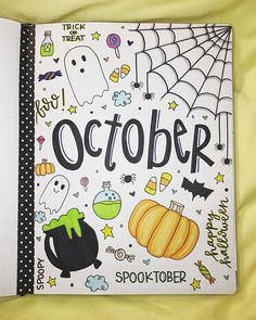 an open notebook with the words october written in black on it and halloween themed items