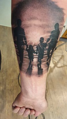 a man with a tattoo on his leg holding hands with two children and an adult